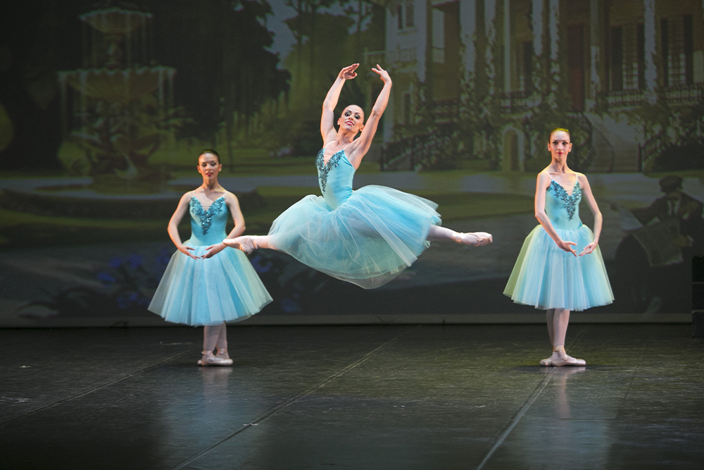 Tre ballerine classiche in tutù azzurro sul palco