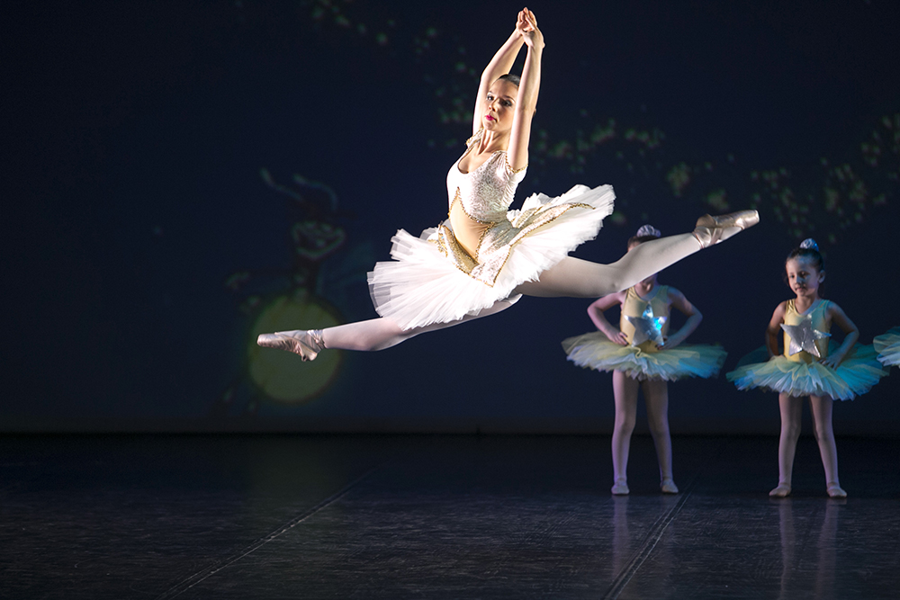 Ballerina in grand jeté durante il saggio di danza classica